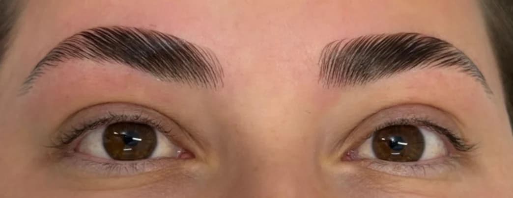 Depois: as mesmas sobrancelhas com Brow Lamination, os fios alinhados e elevados por cima da micropigmentação.